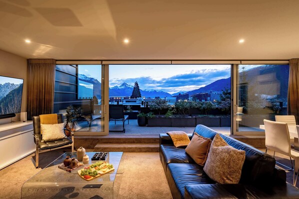 Designer Living with Fireplace and Luxury Touches
Step into this luxurious living room with expansive windows offering breathtaking views of Lake Wakatipu and the surrounding mountains. Ideal for relaxing after a day of skiing or mountain biking.