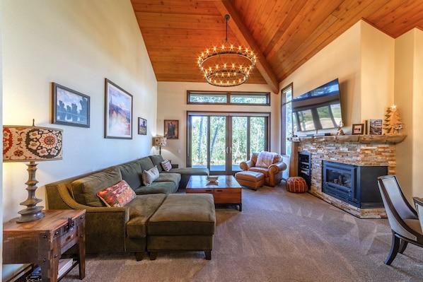 Large living area with gas burning fireplace, TV w/ smart features, and private deck access.