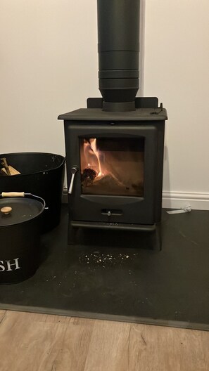 Logburner with a basket of logs supplied