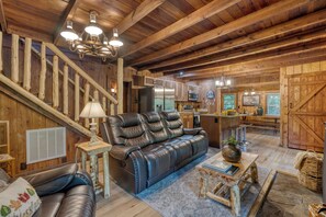 Living room features a comfortable leather sofa, fireplace, and TV.