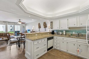A spacious kitchen with a granite countertop and stainless steel appliances