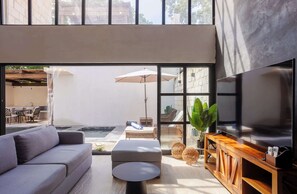 There’s a beautiful sunlit sitting room with a comfy sofa and a large Smart TV