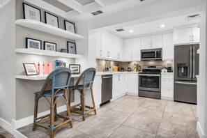 Fully equipped with Nespresso machine, blender, stainless steel appliances, service for 8, and 2 high bar stools for casual dining or remote work.