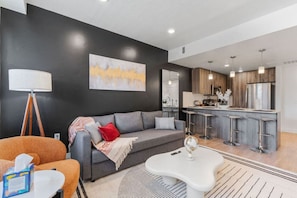 Bright and inviting – enjoy the perfect mix of comfort and style with a TV, plant, and tall lamp in our living room.