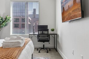A perfect blend of art and nature – our bedroom offers a king-sized bed, desk area with scenic views, and a lovely painting.