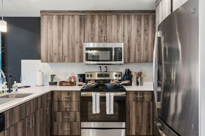 Our kitchen provides the perfect setting for cooking and dining, with a bar counter, high stools, and a complete set of utensils.