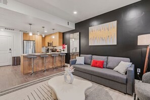 Unwind in our elegant living room, with comfortable sofas, a stylish center table, and a large TV.