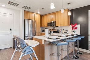 This kitchen has it all – an oven for cooking, a bar counter with high stools, and a toddler chair for your little one.