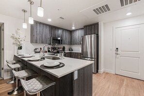 Whip up your favorite dishes in our kitchen, featuring a modern oven, convenient bar counter, and coffee maker.