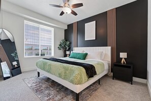 Rest easy in our luxurious bedroom with a king-sized bed, desk area, and flat-screen TV.