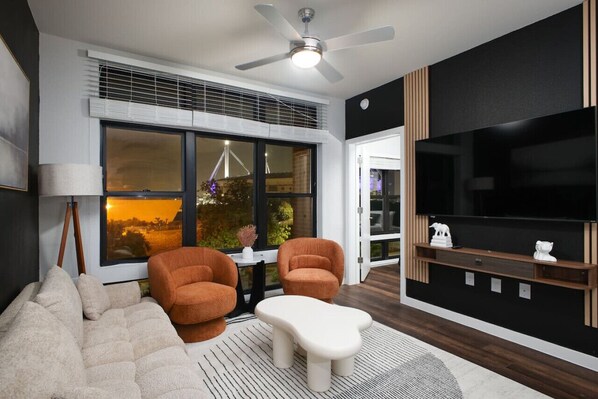 Relax in our cozy living room, where comfy sofas, large windows, and vibrant greenery create a serene ambiance.