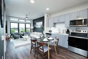 Dine in a space where comfort meets style, with a white orchid centerpiece and a circular mirror.