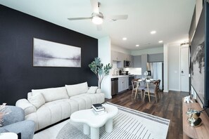 Our living room combines comfort and creativity, with cozy seating, artistic decor, and a view through the large window.