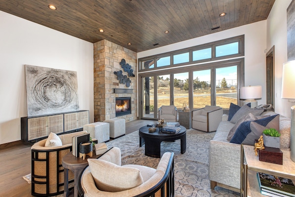An open concept great room with large bright windows, cozy fireplace and plenty of seating