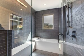 A large tub and rain shower enclosure in the Master Suite