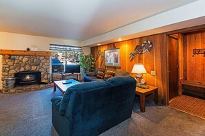 Living room w/ sofa sleeper, TV, DVD player, wood burning fireplace