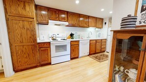 Kitchen with toaster, drip coffee maker, blender, electric stovetop and more