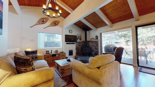 Cozy living space with fireplace, TV, and deck access