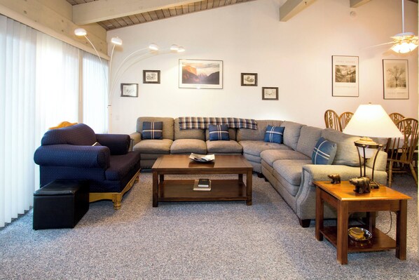 Living room with flat screen TV, fireplace, and balcony access