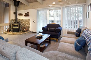 Living room with flat screen TV, fireplace, and balcony access