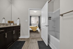 Refresh and rejuvenate in this bright bathroom featuring a spacious vanity and all the essentials for a tranquil start to your day.