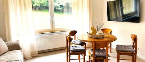 Wohnzimmer mit Esstisch und Smart-TV