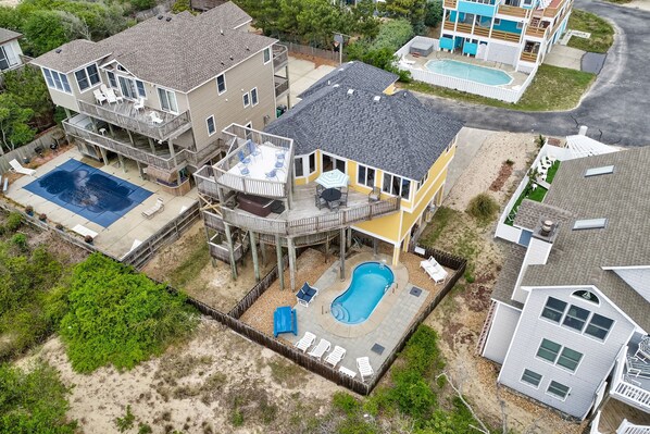 Experience the perfect blend of luxury and convenience at 'Here Comes the Sun'! 🌞 Dive into your private pool or stroll just steps to the beach. This stunning aerial view showcases it all. 🌴🏡