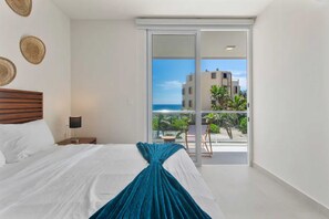 Serene bedroom with ocean views and darkening shades for restful sleep.