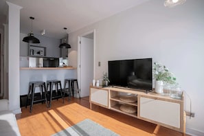 Cozy living area with modern amenities and a stylish kitchen bar, perfect for relaxing or entertaining.