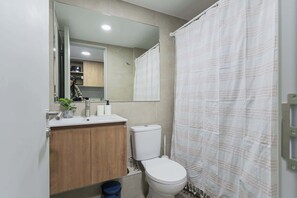 Modern bathroom with sleek wooden vanity and large mirror, perfect for a refreshing start to your day.
