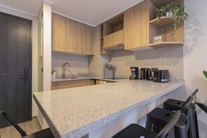 Cocina gourmet con isla central y vista a la ciudad.