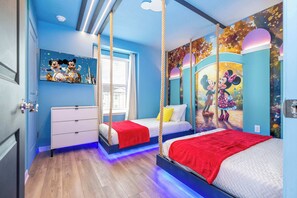 This adorable kids' bedroom features a Minnie and Mickey Mouse theme with charming wall art, a cozy bed, and playful hanging swings for a magical, fun-filled stay!