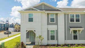 Discover this beautiful modern townhouse with contemporary gray and white exterior, lush landscaping, and a welcoming entryway, perfect for a comfortable stay!