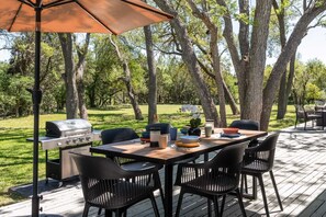 The property has abundant outdoor spaces including a huge back deck with shaded outdoor dining option and BBQ grill. .