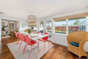 Dining room table that sits 10 with french doors leading to outside patio with pool.
