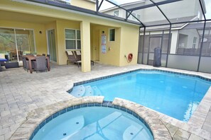 View from pool and spa of back of house and covered lanai