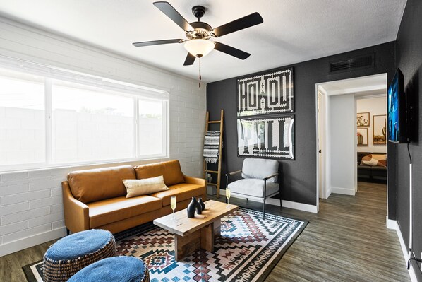 Bright and open living area with a Smart TV, designer furnishings and a dining table with seating for 2 guests.