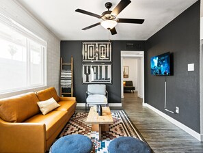 Bright and open living area with a Smart TV, designer furnishings and a dining table with seating for 2 guests.
