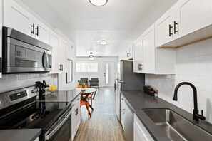 Sleek and functional kitchen equipped with stainless steel appliances, modern cabinetry, and a cozy dining nook—perfect for enjoying a quick meal or morning coffee.