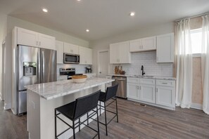 Full kitchen with stainless steel appliances and breakfast bar with seating for 2