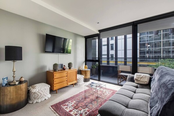 The living room has been beautifully styled as a space to relax with a comfortable lounge and wall-mounted TV.
