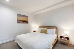 The bedroom features a plush queen-sized bed with comfy carpet underfoot. 