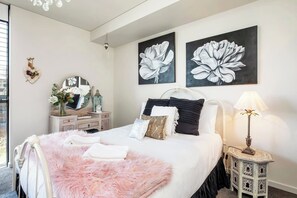 The light and airy bedroom features a queen-size bed, built-in robes and large windows to maximise natural light. 
