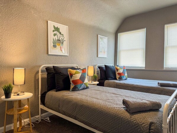 The twin bedroom serene ambiance invites you to relax, with a plush bed that promises a restful night's sleep.
