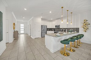 Enjoy a stylish kitchen with fridge, oven, kettle, and sleek design elements for culinary enthusiasts