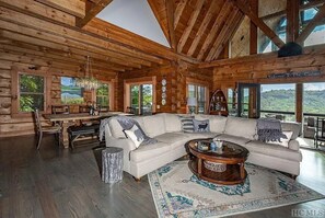 Expansive living room with comfortable couch, gas log fireplace, flat screen tv