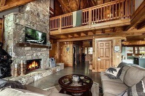 Expansive living room with comfortable couch, gas log fireplace, flat screen tv