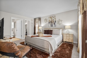 Cozy up in this warm-toned bedroom featuring a king bed, flat-screen Roku TV, and a private en suite bathroom. Ample storage in the spacious walk-in closet makes it perfect for extended stays.