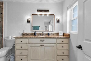 A bright bathroom with sleek, comfortable design featuring a glass shower and elegant tile walls, creating a modern, refreshing space.