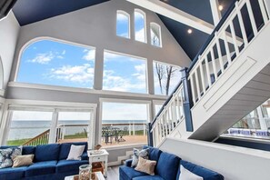Two Story Vaulted Ceilings with Big Picture Windows allow Sunlight to Pour in